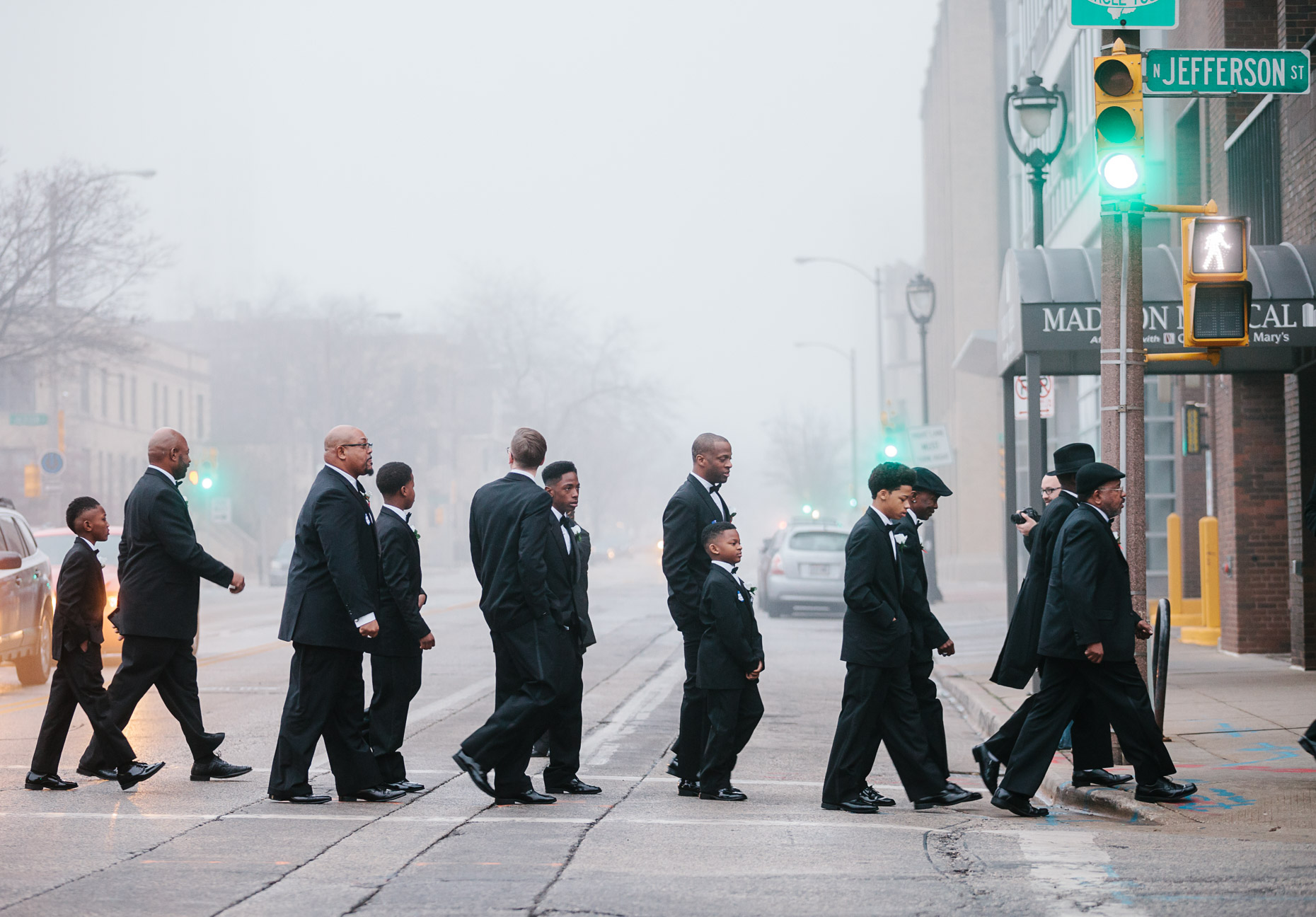 Andre Lee Ellis, the organizer of the 500 Black Tuxedos Event, leads the participants from the bus drop off point on Cathedral Square to the luncheon location at  the Chic Cafe on Jefferson Street Saturday December 12th, 2015 in Milwaukee, Wisconsin.