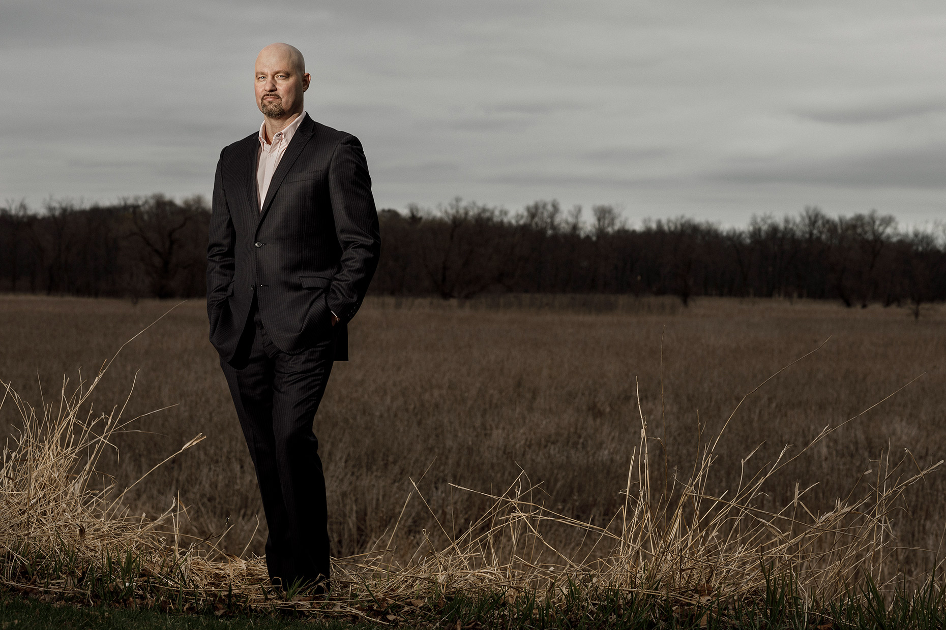 corporate photographer Midwest - Chad Jampedro, a businessman, stands in a field