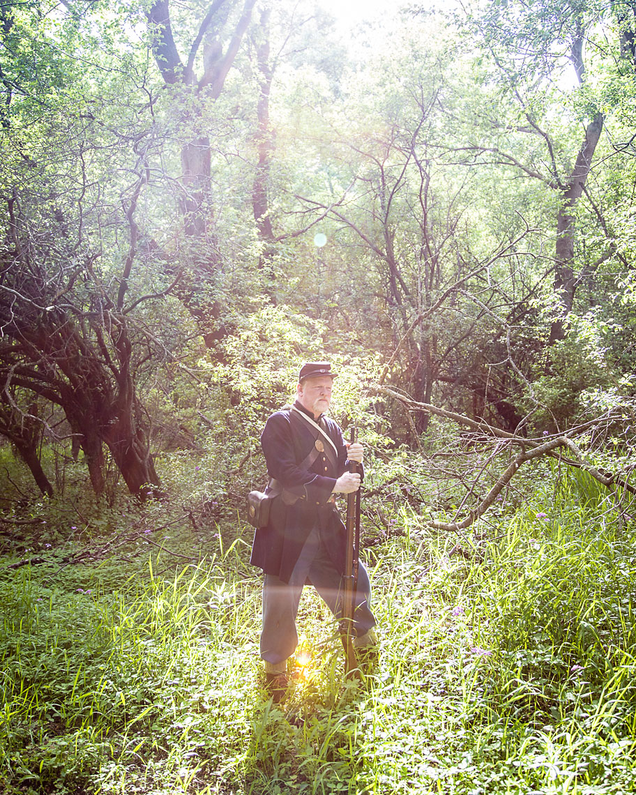 editorial photographer Midwest - a Civil War reenactor hold a gun standing in a field