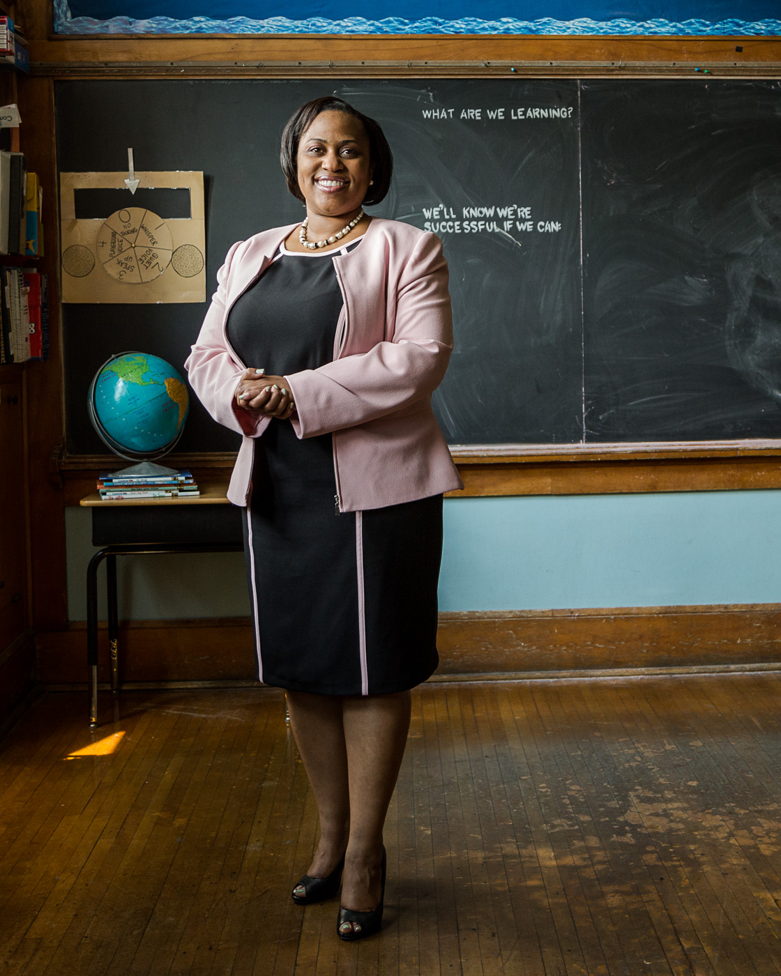 editorial portrait - portrait of Dr Darienne Driver in a grade school classroom with a chalkboard