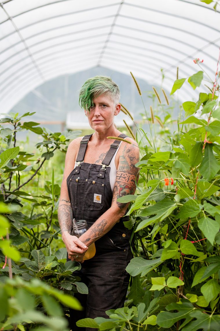 agriculture photographer Wisconsin - a female farmer wearing overalls in a hoop house