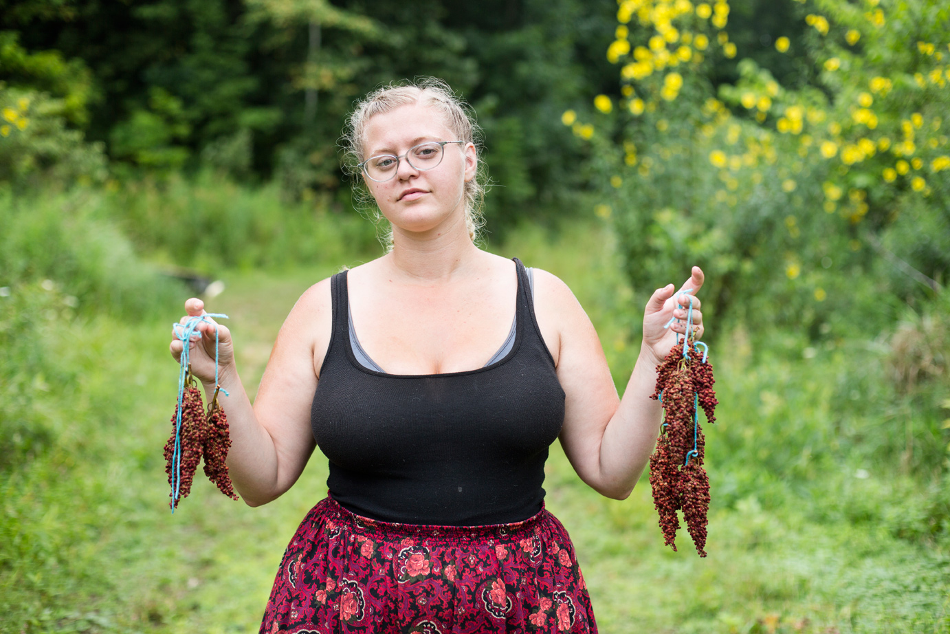 Sara Stathas portrait photographer - a farmer holds up harvested sumac 