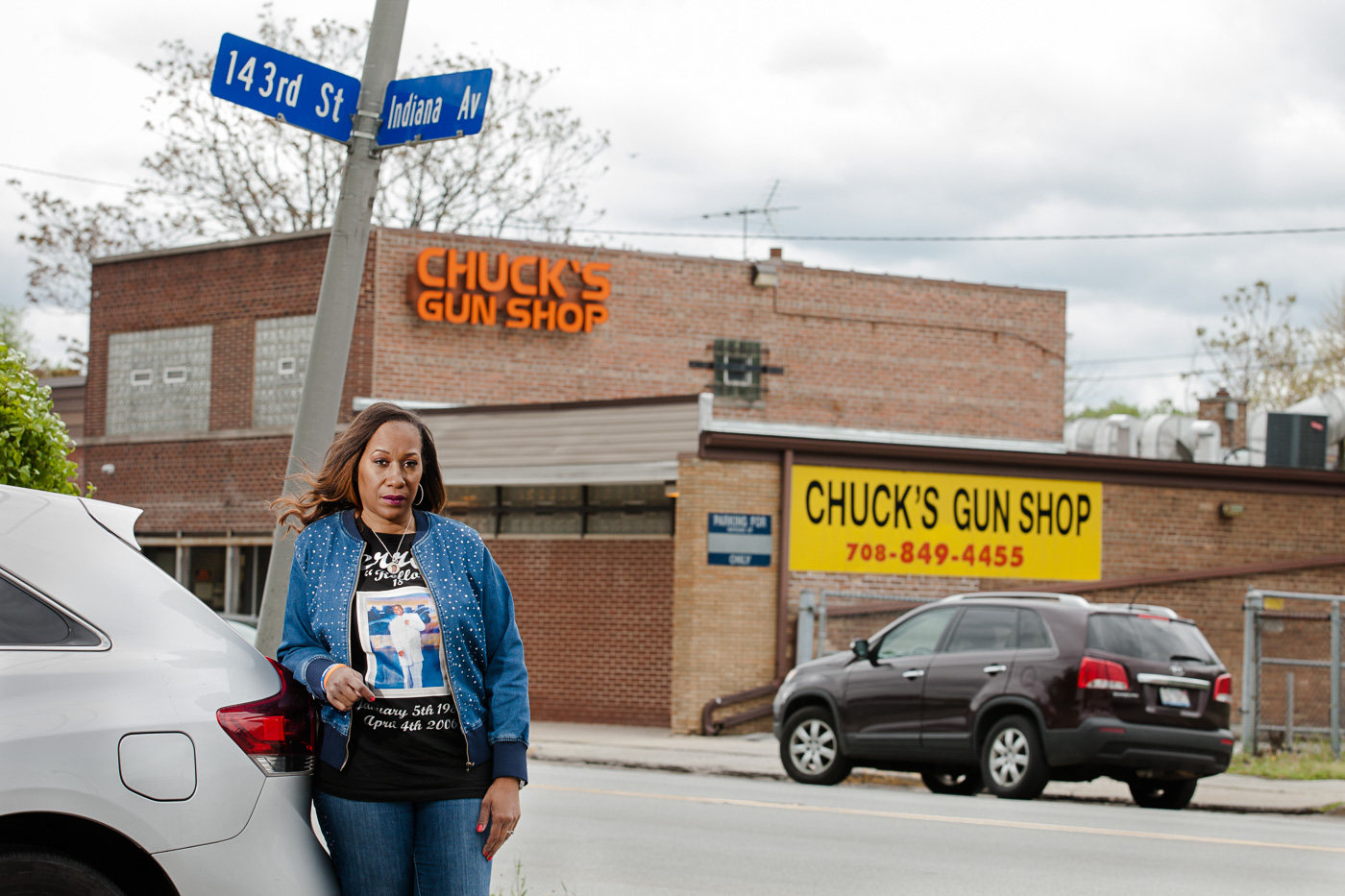 editorial photographer Chicago - an African American woman stands in front of a gun shop in Chicago