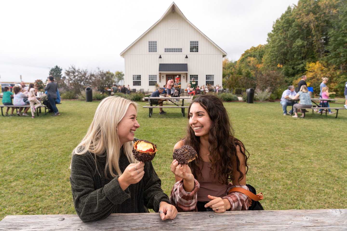 farm photographer - two women enjoy eating caramel apples