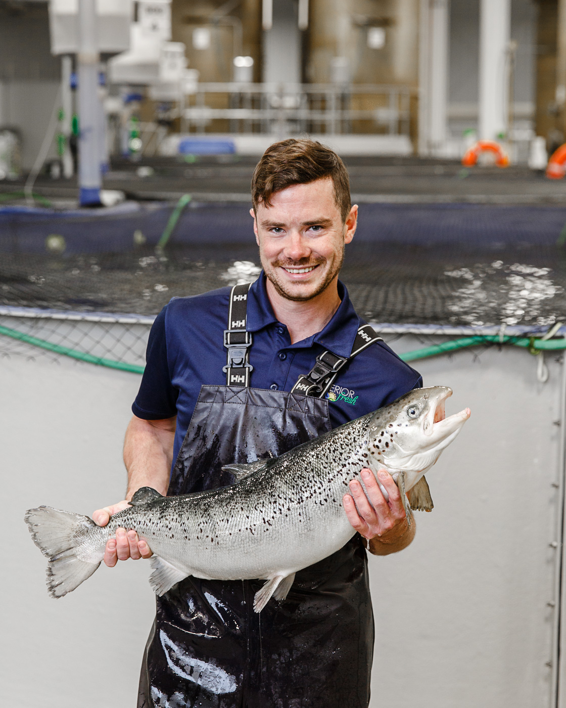 Kyle Woolever, aquaculture manager at Superior Fresh based in Hixton, WI holds a farm raised salmon.