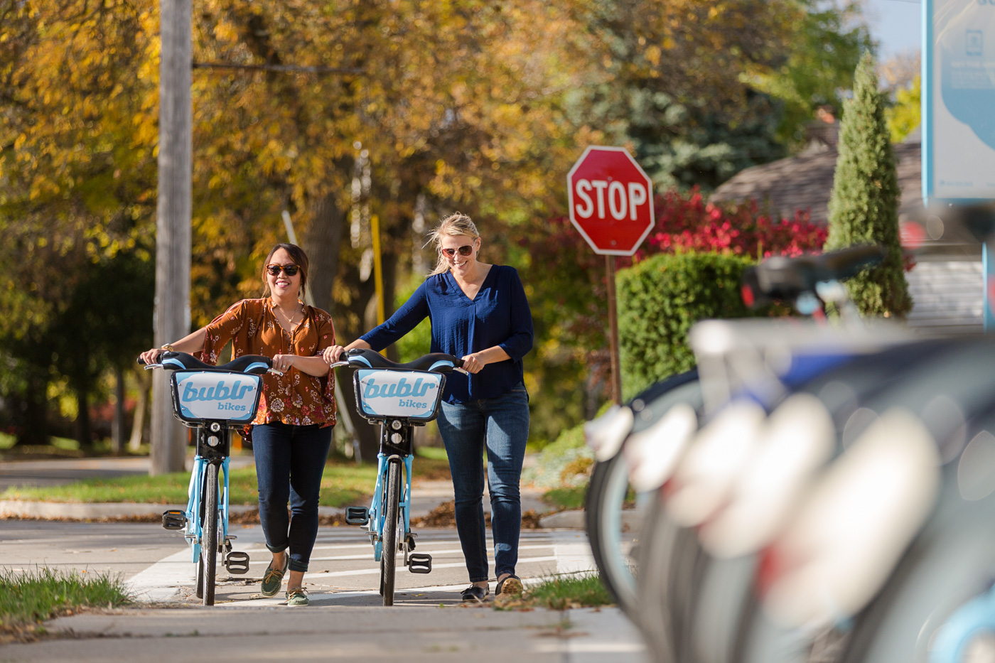 comercial photographer Milwaukee - two women walk along side their bikes for VISIT Milwaukee