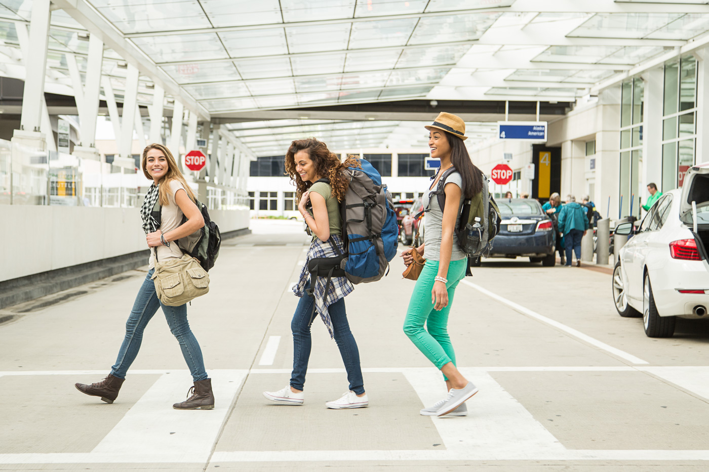 commercial photographer Wisconsin - three young women cross the street at the arrivals area at Mitchell International airport in Milwaukee