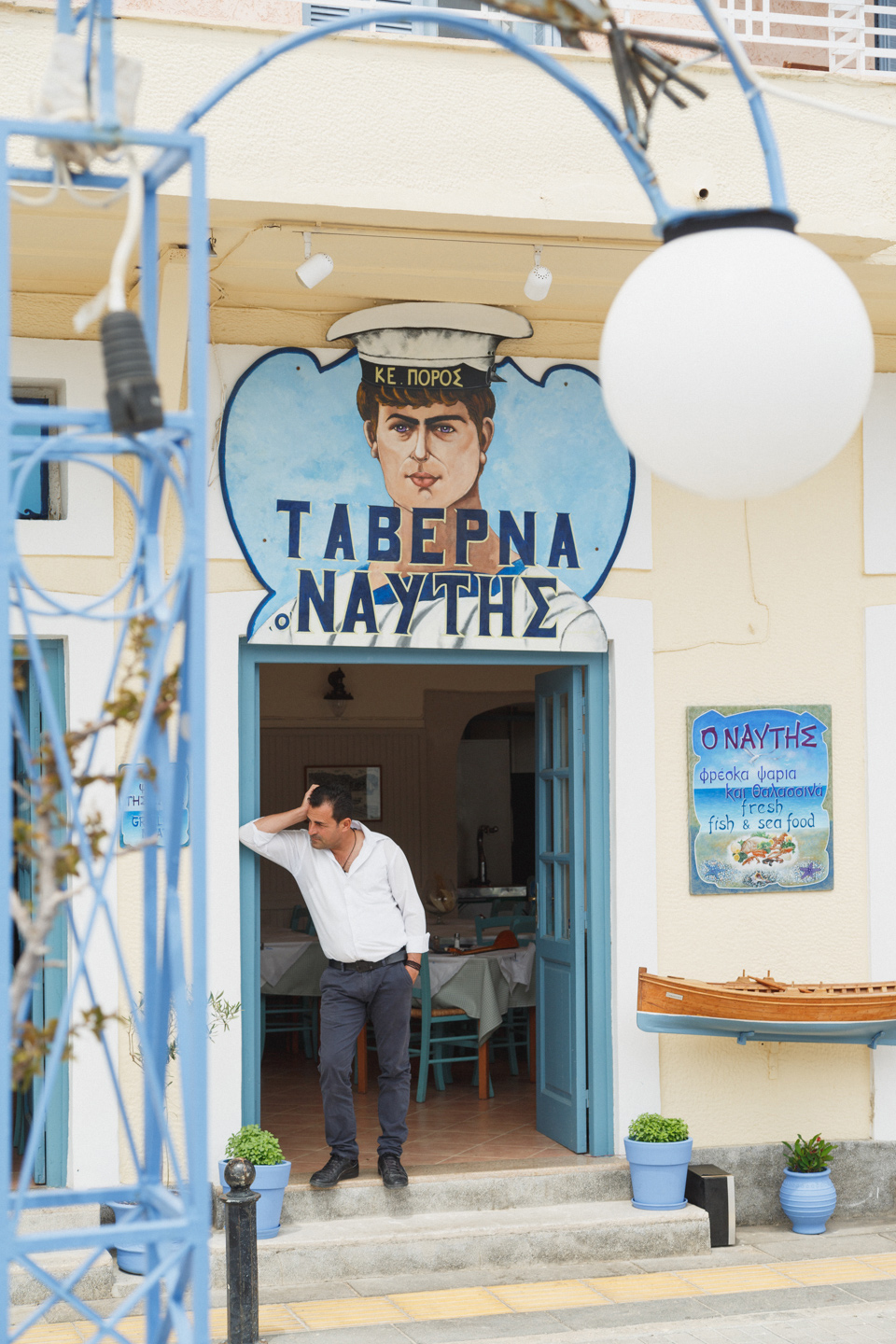 food photographer Greece - a workers stands in the doorway of a taverna on a Greek Island