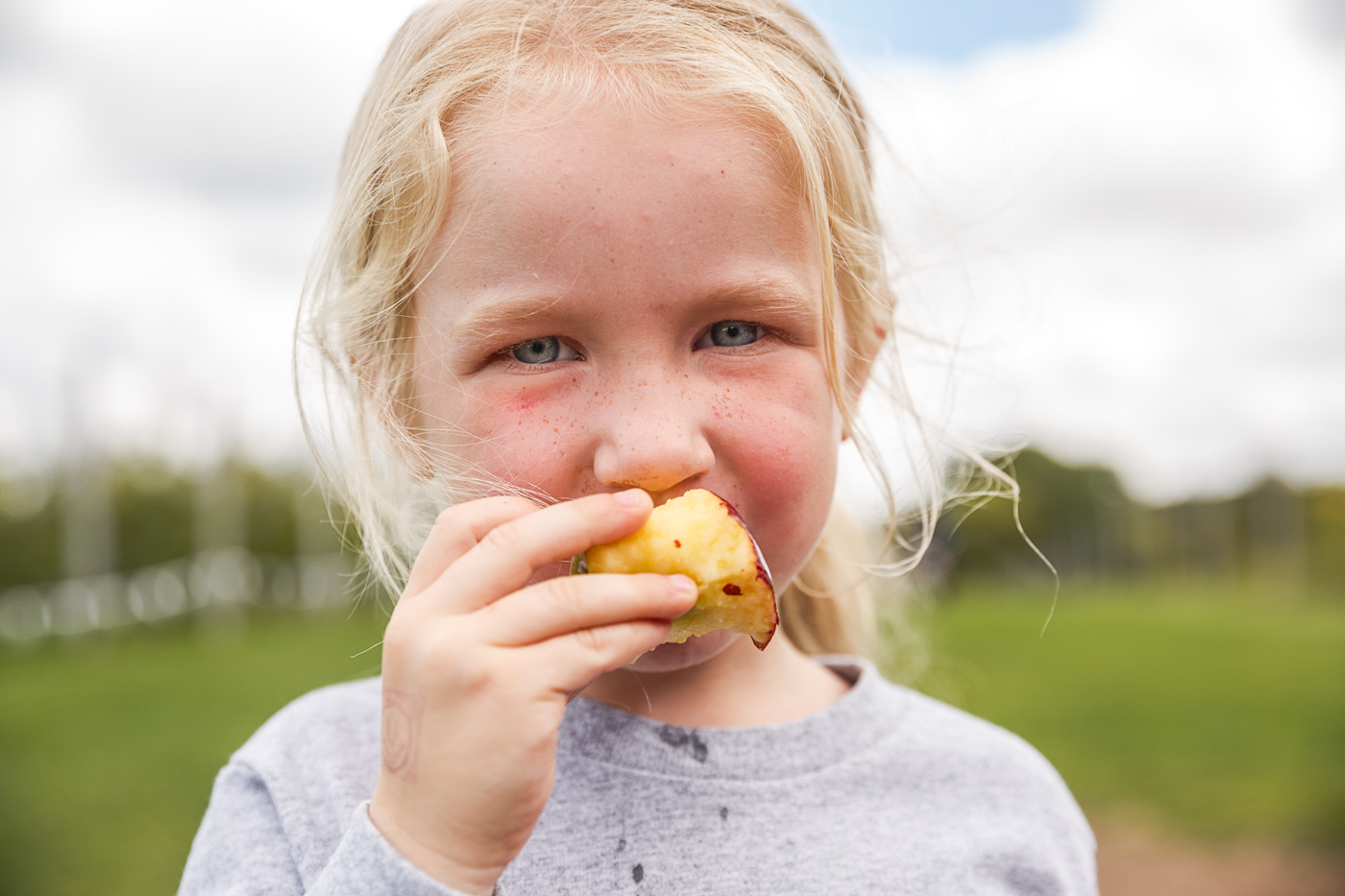 farm photographer - a young woman eats an apple